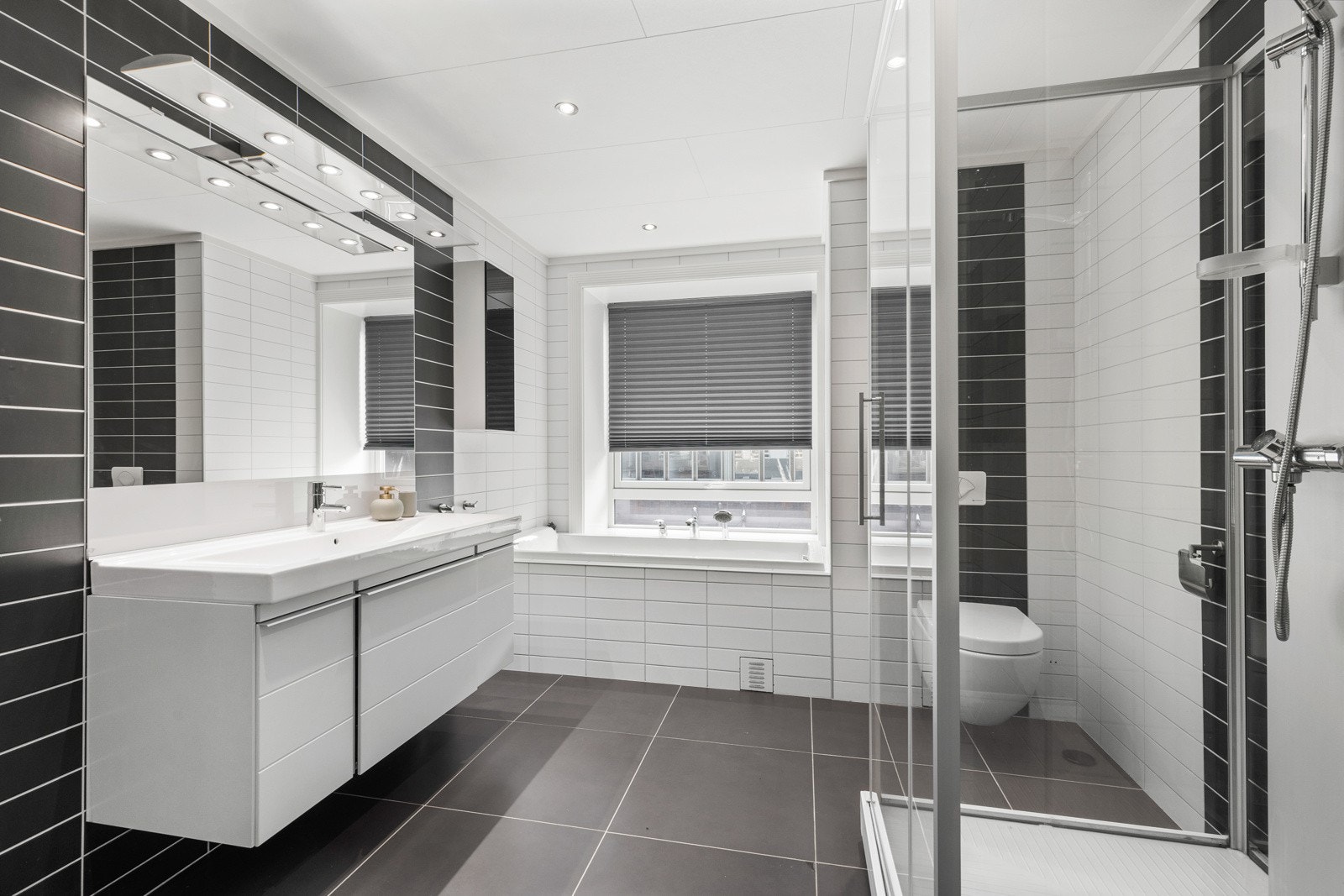 Baderommet er over 9 m² og har ett stort dusjkabinett og innfliset badekar. Galleribilde