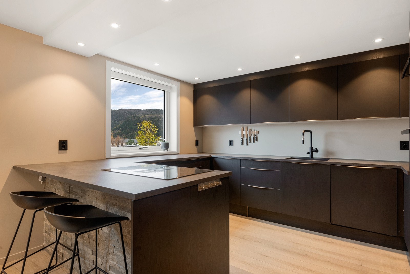 Lekkert kjøkken som holder et moderne preg og har rikelig med skap- og benkeplass Galleribilde