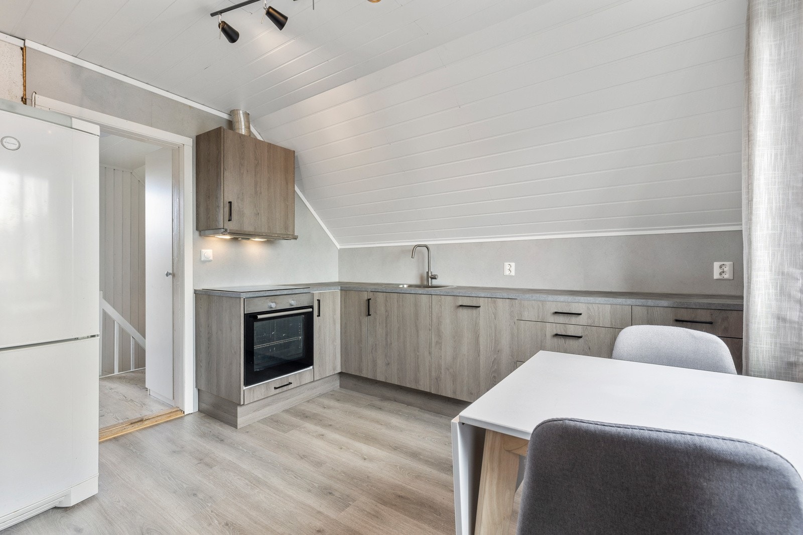 Kjøkkenet er fra nyere tid med integrerte hvitevarer og frittstående kjøleskap Galleribilde