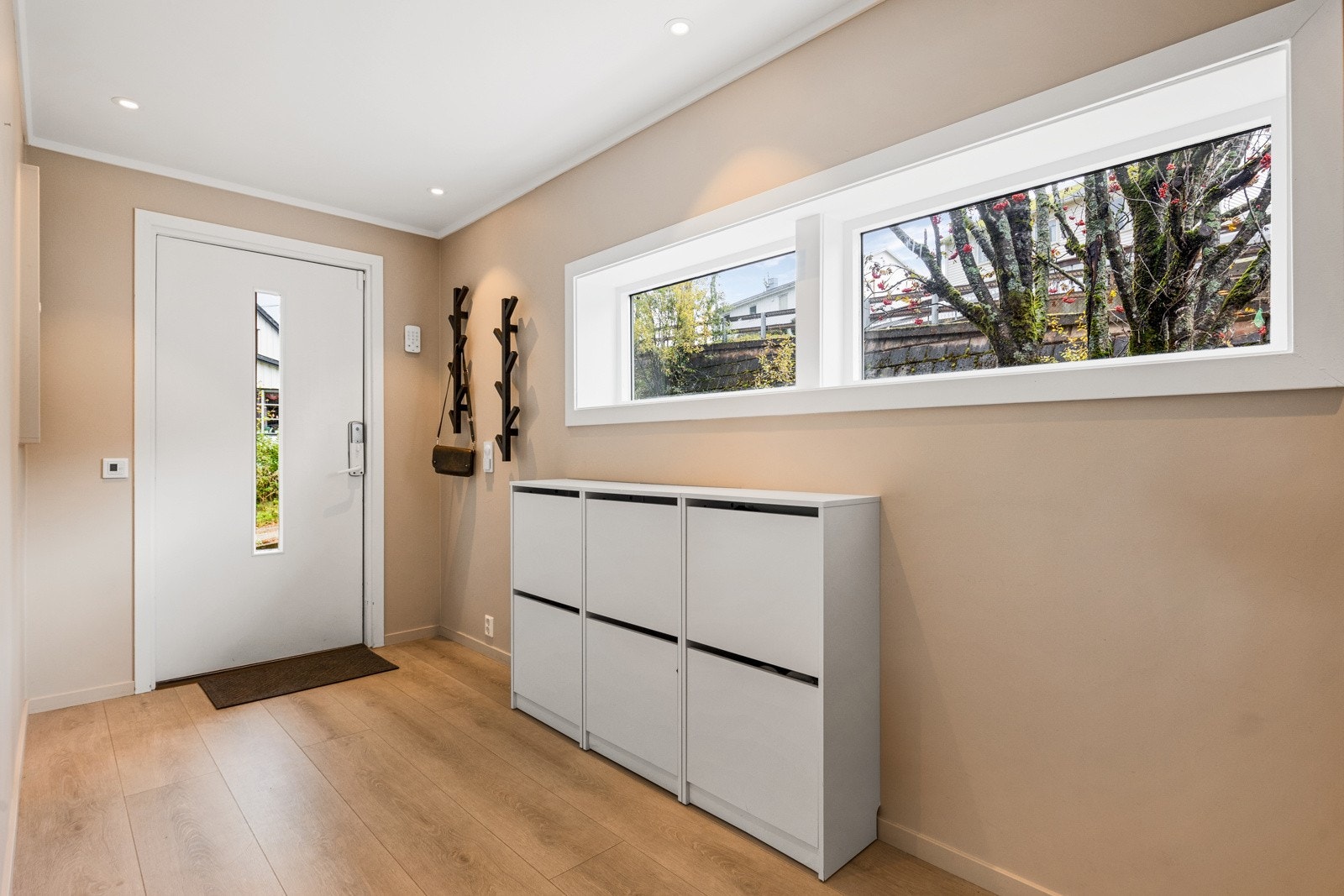 Lys og innbydende entré med god plass for oppheng av yttertøyet Galleribilde