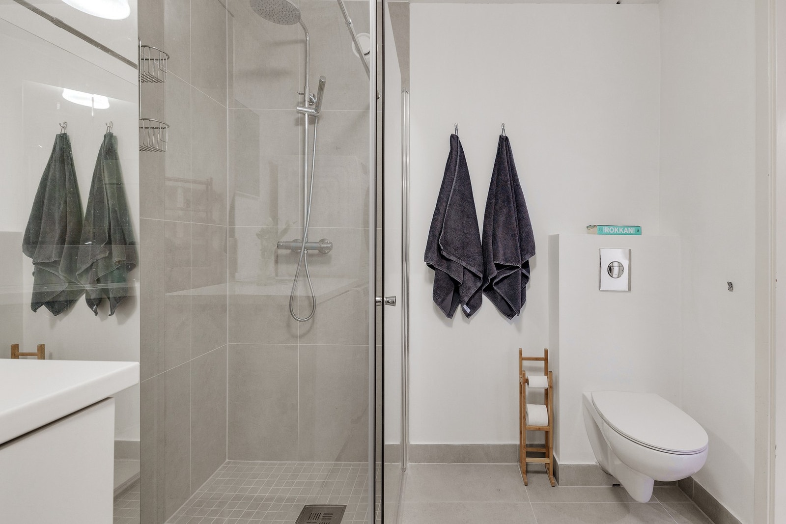 Innredning med vegghengt toalett fra 2023, samt vegghengte dusjdører i glass. Galleribilde