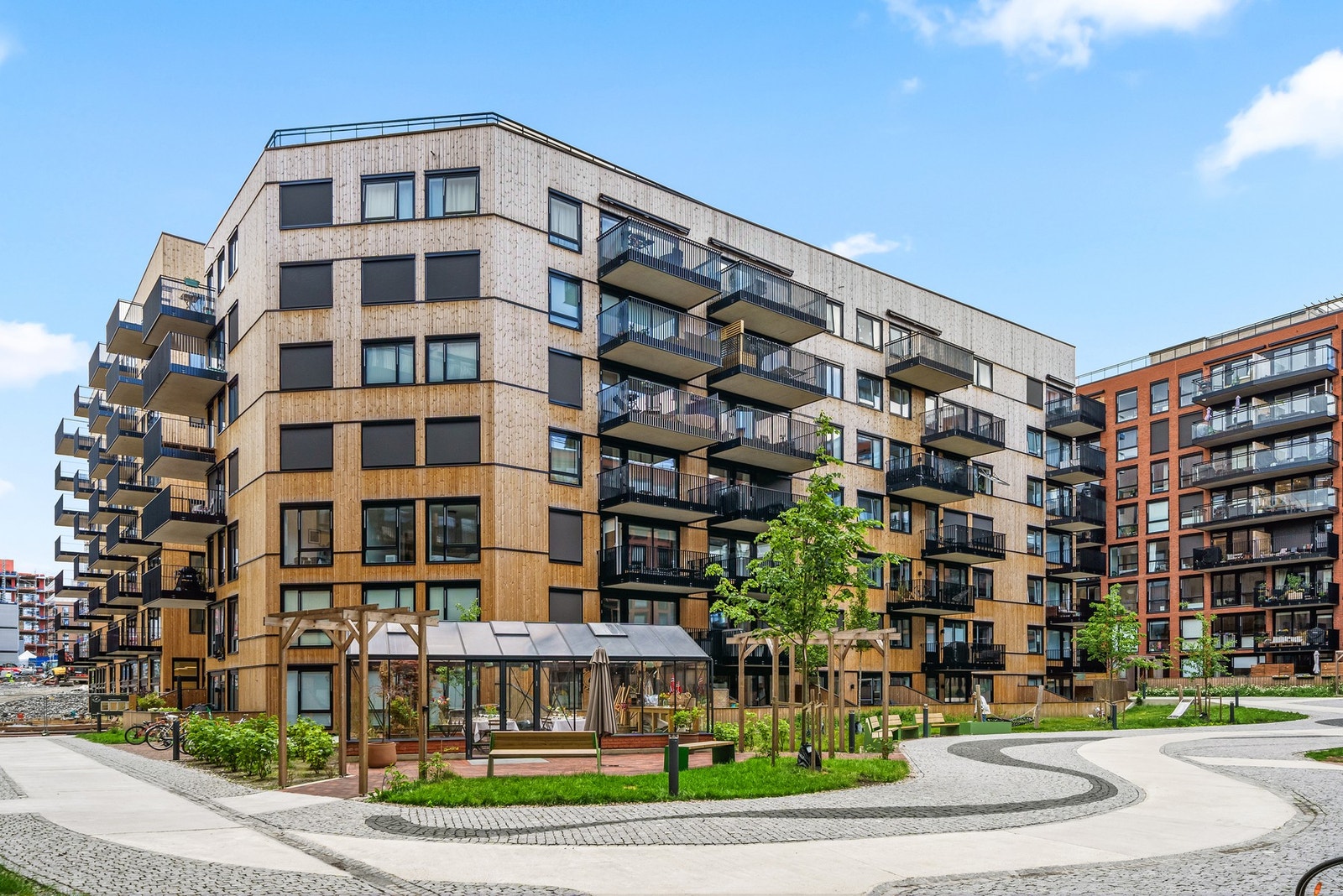 Fellesområdene har brostein, beplantning og hyggelige sitteplasser Galleribilde
