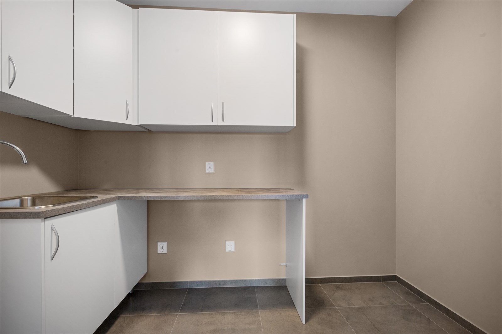 Vaskerom med fliser på gulv og malt gips på vegger. Varmtvannsbereder. Vaskeromsinnredning med over og underskap. Utslagsvask Galleribilde