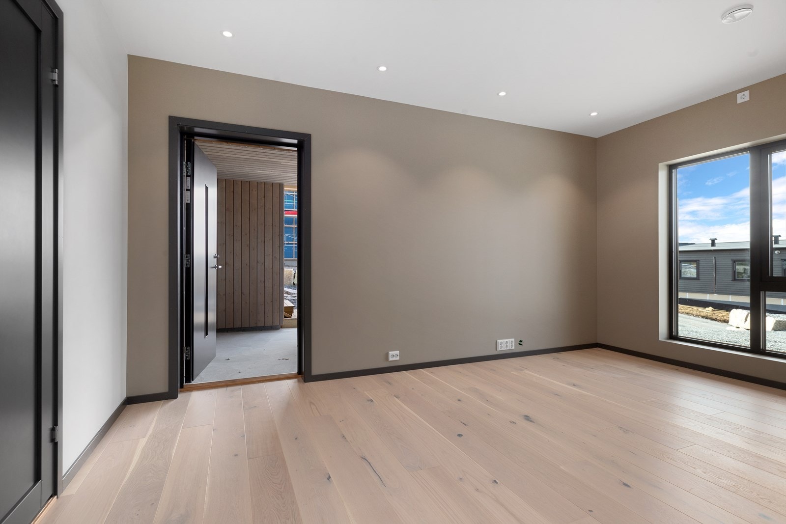 Stue i underetasjen med enstavs eikeparkett på gulv og malt gips på vegger. LED downlights i tak. Fra stua har du direkte utgang til carport og isolert utebod Galleribilde