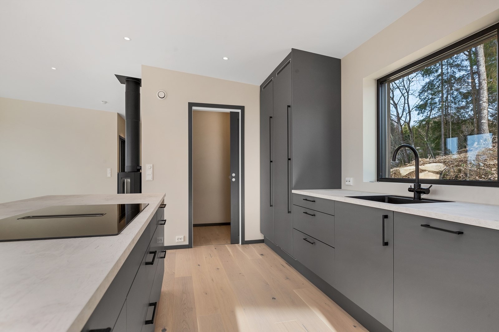 I tilknytning til kjøkkenet finner du en praktisk bod med skyvedør med enstavs eikeparkett på gulv og malt gips på vegger Galleribilde