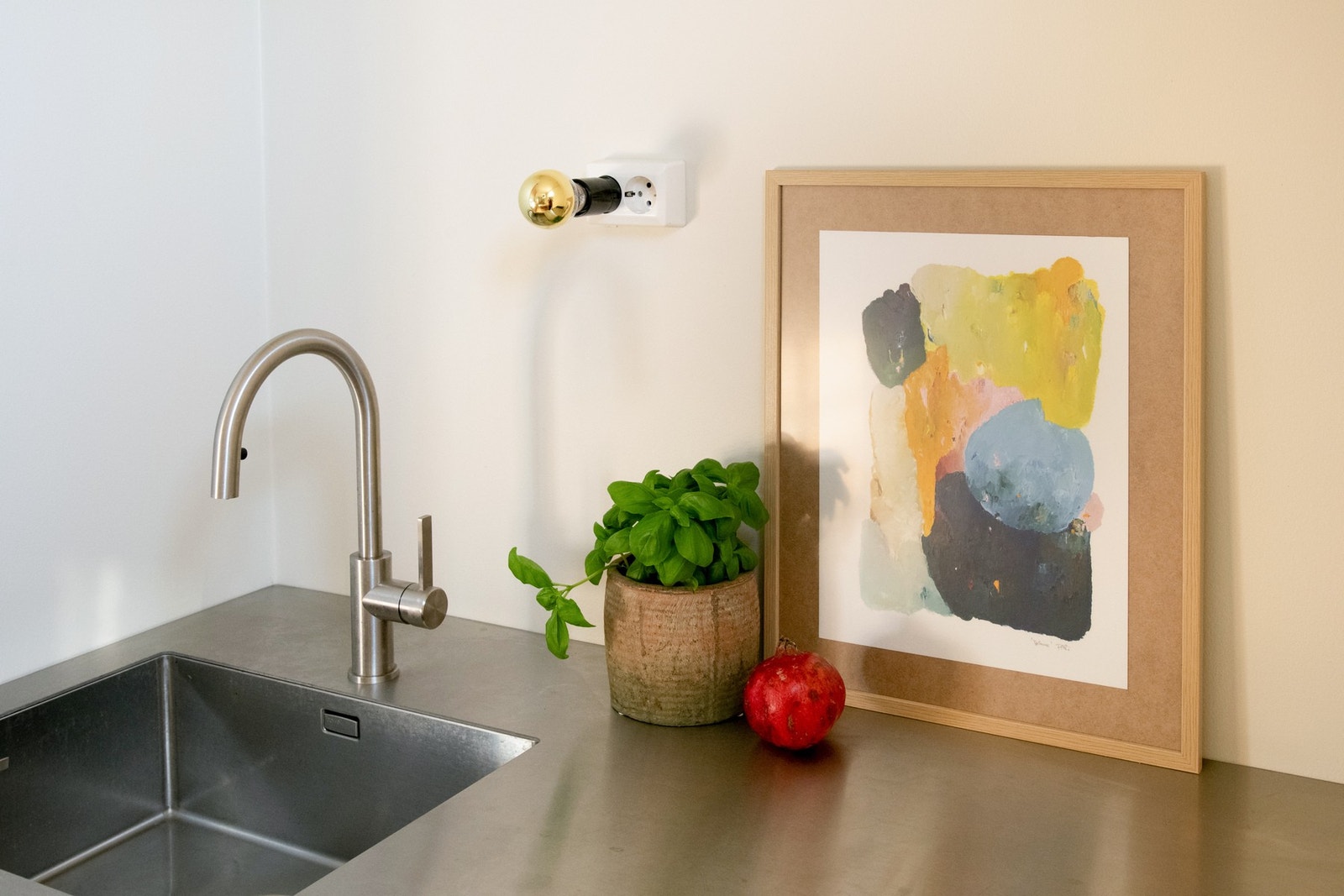 Kjøkkenfronter og benkeplaten i rustfritt stål tilfører både et industrielt preg og funksjonalitet, med vedlikeholdsvennlige materialer. Galleribilde