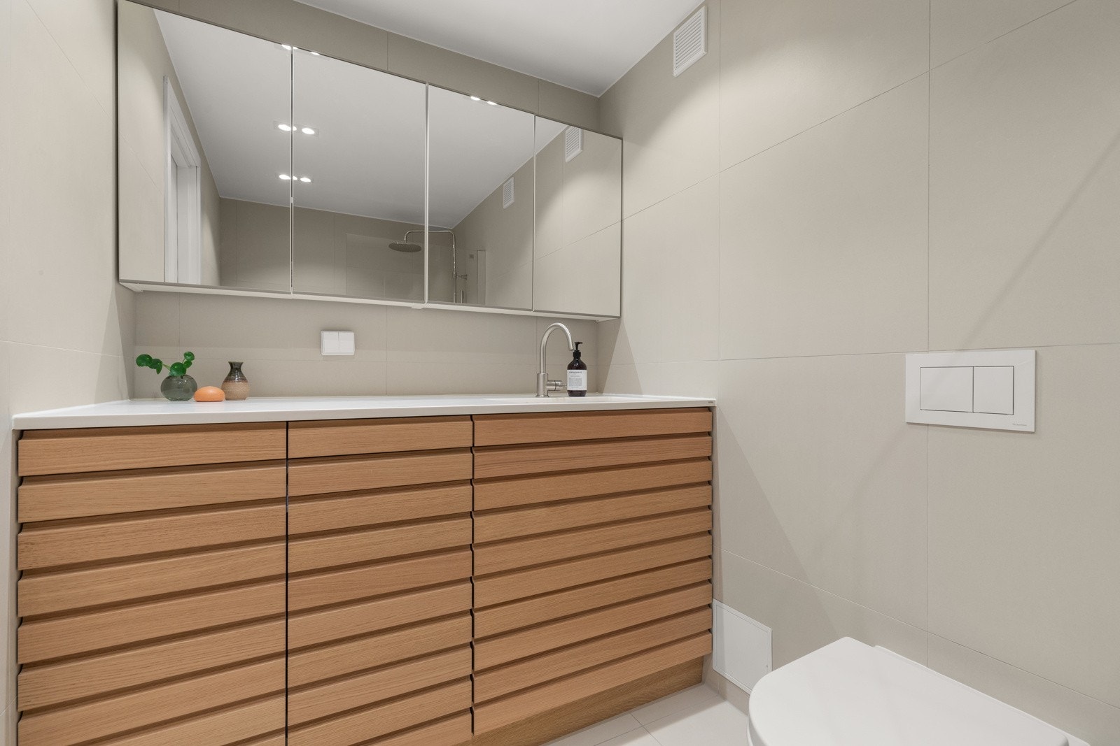 Badet er nytt fra 2022 og kombinerer funksjon med stil. Badet fremstår moderne med tidsriktige farger og smarte løsninger for oppbevaring. Behagelig varme i gulv. Galleribilde
