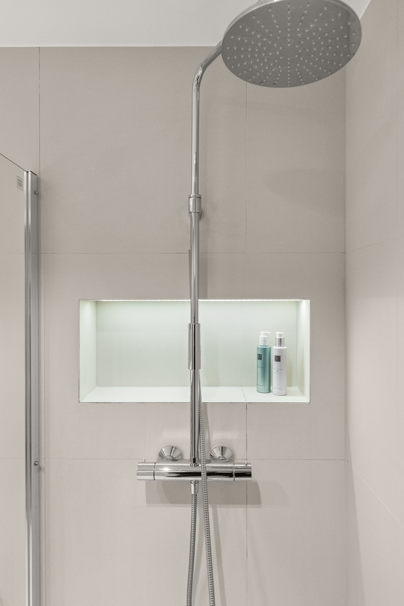 Dusjnisje med glassdør og regndusj fullfører det moderne inntrykket. I dusjen har man 1 nisje for oppbevaring av såpe/shampoo. Galleribilde