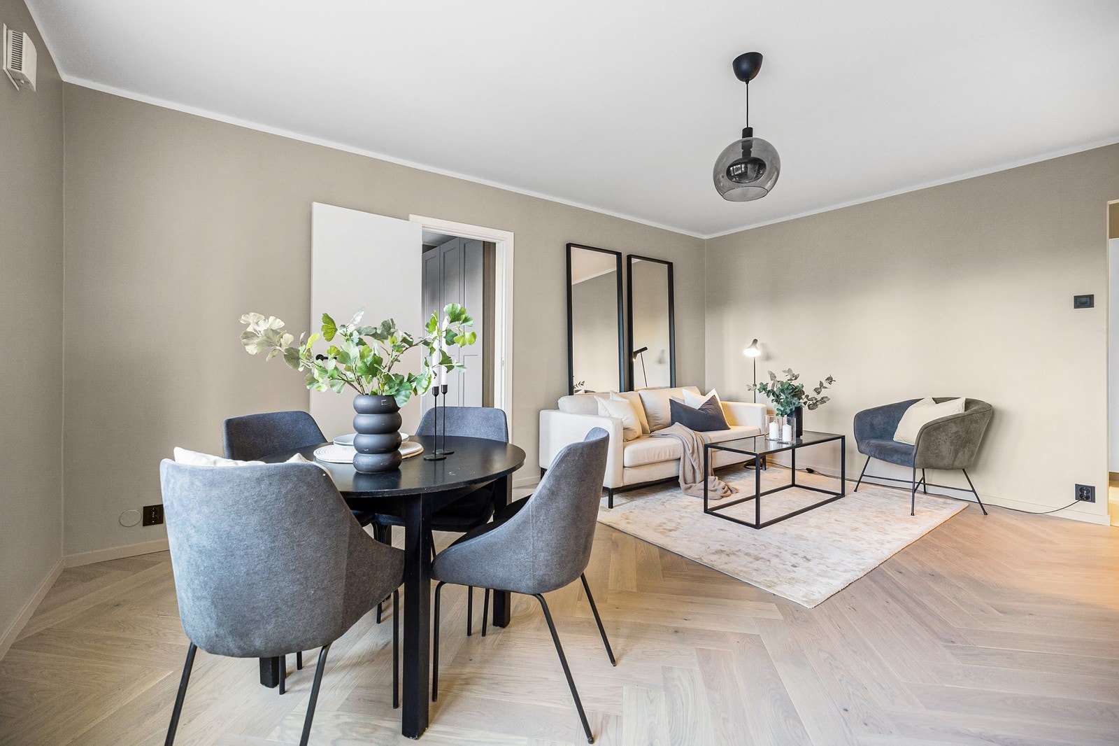 Hyggelig stue med inngang til to soverom og balkong Galleribilde