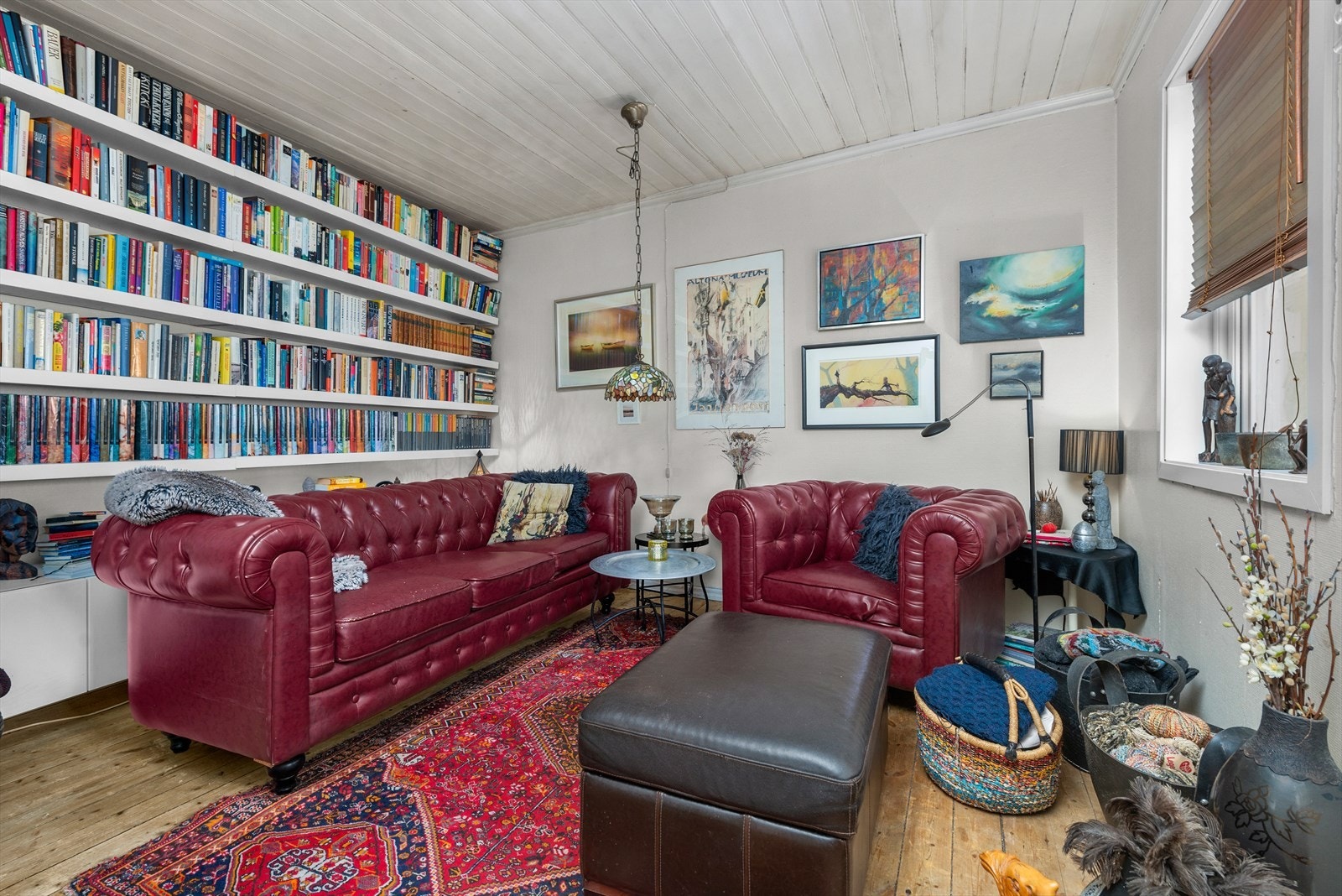 Koselig stue med lysmalt panel, store bokhyller og rikelig med naturlig lys. Perfekt for hyggelige stunder og avslapning. Galleribilde