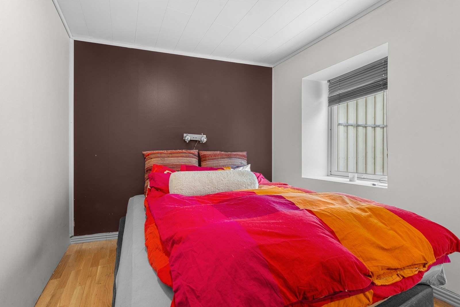 Lyst soverom med god plass til dobbeltseng og naturlig lysinnslipp fra stort vindu. Galleribilde