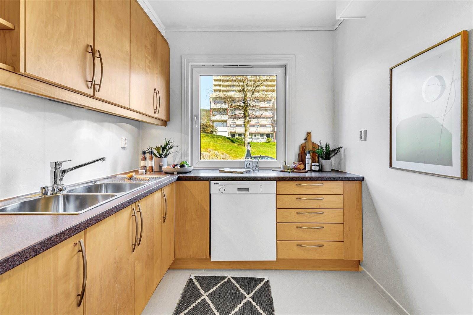 Koselig kjøkken med laminat benkeplate og slette fronter. Galleribilde