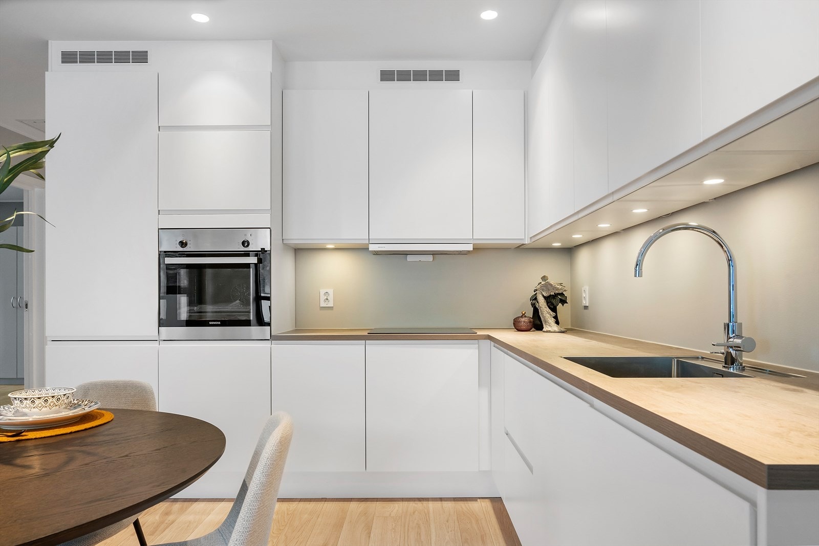 Kjøkkeninnredning med slette fronter og takhøye overskap Galleribilde