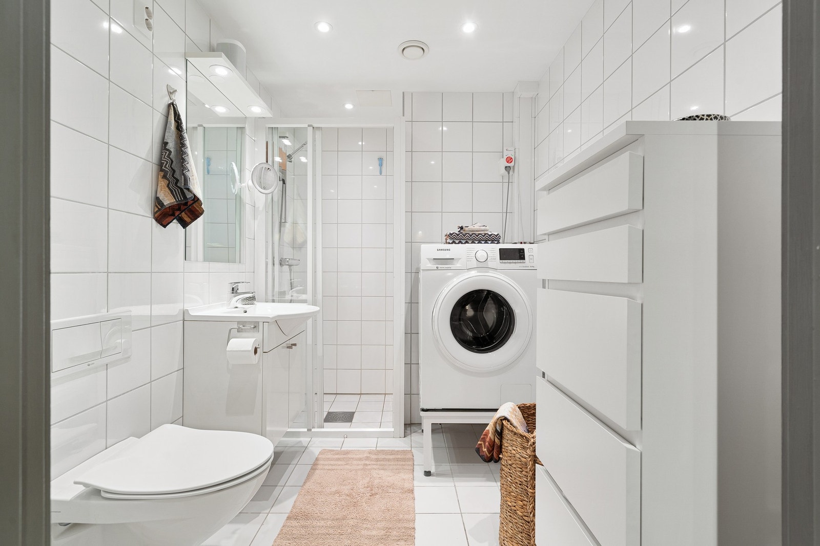 Lyst flislagt baderom med downlights i tak. Galleribilde