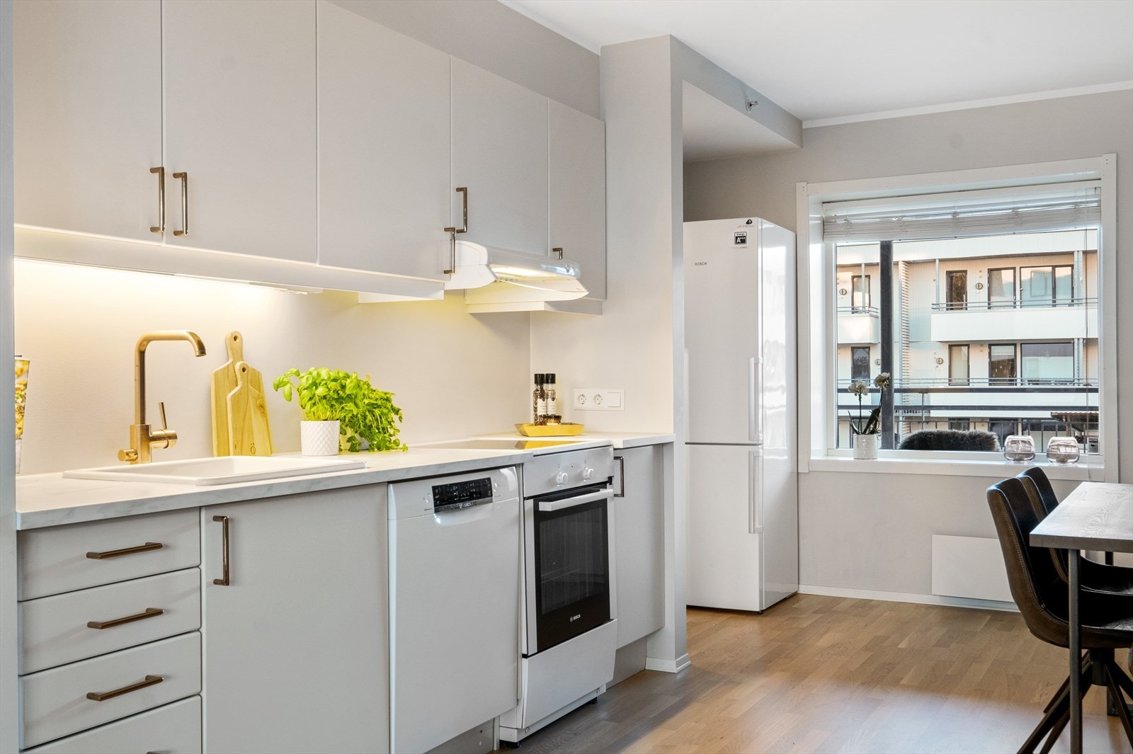 Kjøkkeninnredning fra 2009 med laminert benkeplate, slette skapfronter, malt backsplash og ventilator med kontinuerlig avtrekk. Ny benkeplate, kjøkkenvask og armatur fra 2019. Galleribilde