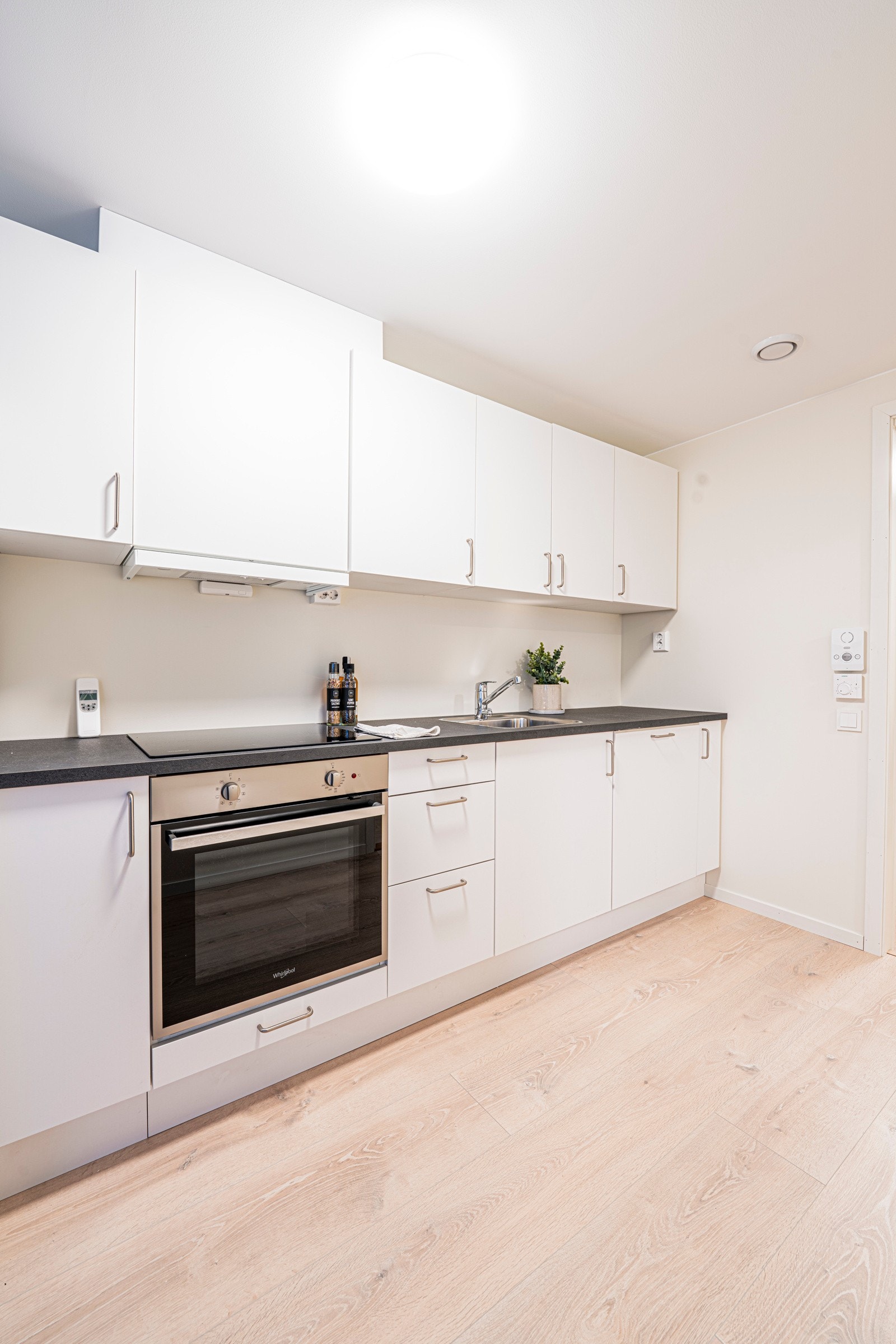 Stilren og tidløst kjøkken med integrert stekeovn og platetopp Galleribilde