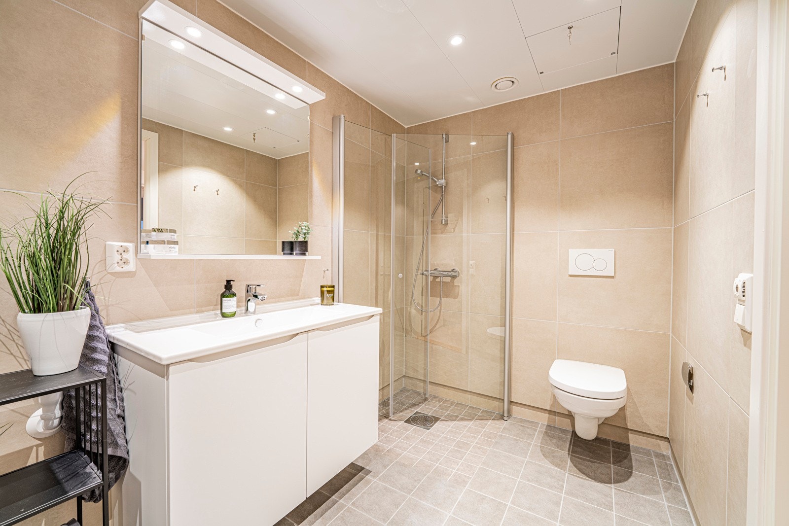 Det flislagte badet er fremstilt i lekre farger og passende innredning. Galleribilde