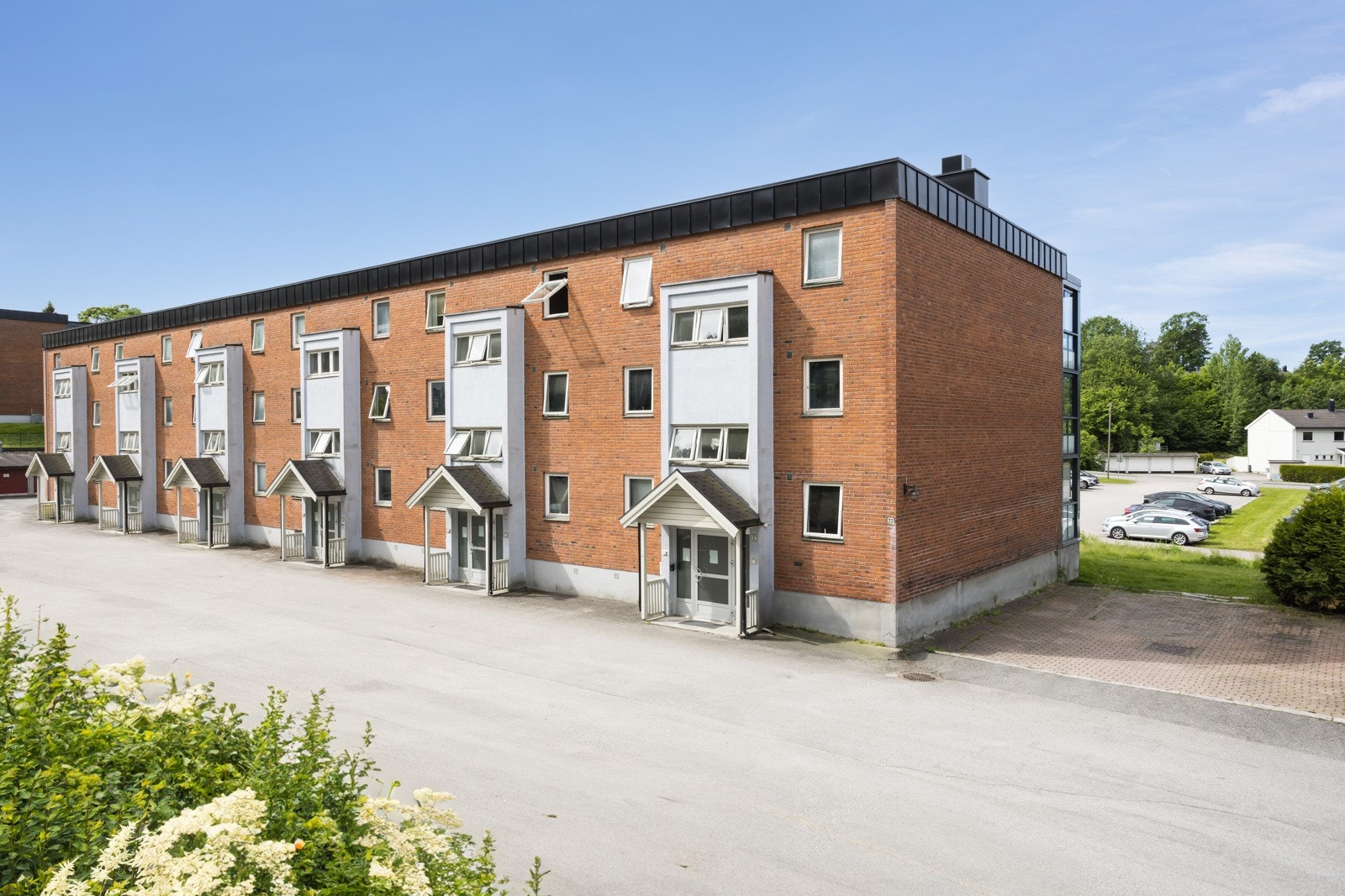 Felles biloppstillingsplass ved inngangspartiene til blokken. Det er mulighet for lading av elbil. Galleribilde