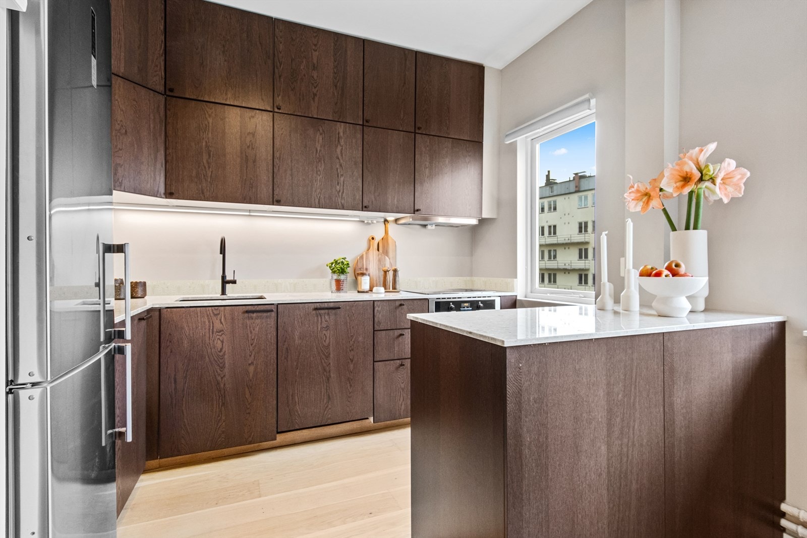 I 2024 ble kjøkken pusset opp med nye fronter, benkeplate i steinkompositt med backsplash og underlimt kum i kompositt. Galleribilde