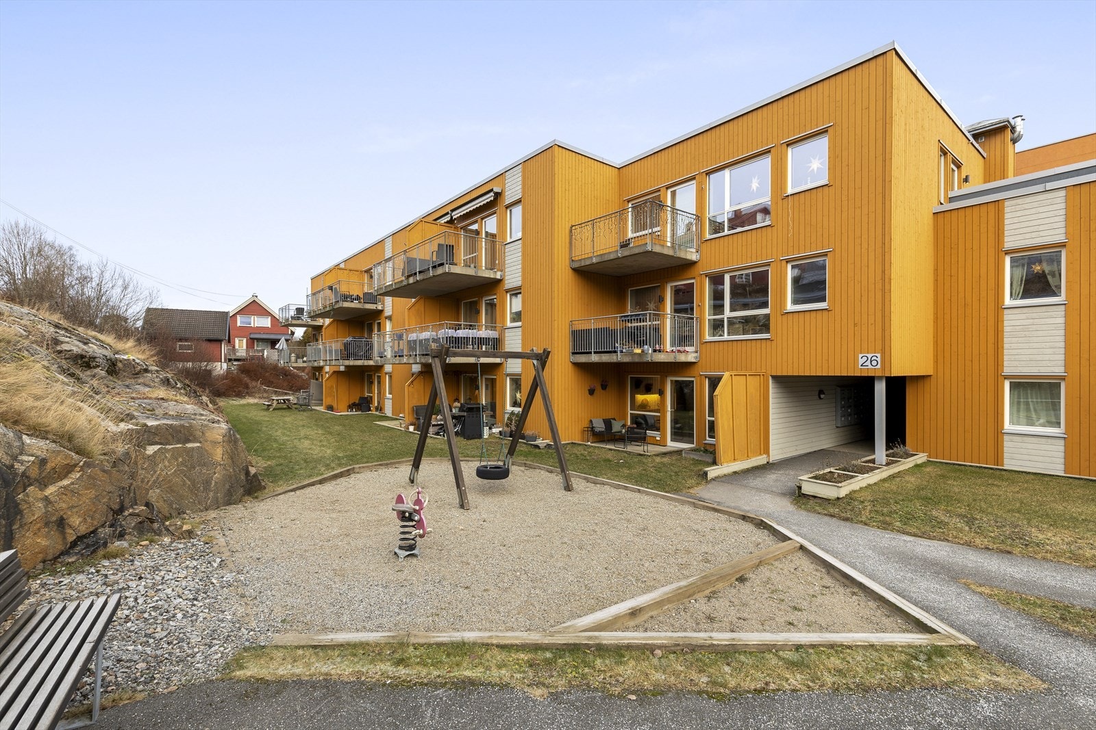Elveveien 26 har pent opparbeidet fellesarealer med lekeplass, plen, krakker, gjesteparkering, garasjeanlegg, asfalterte gangveier Galleribilde