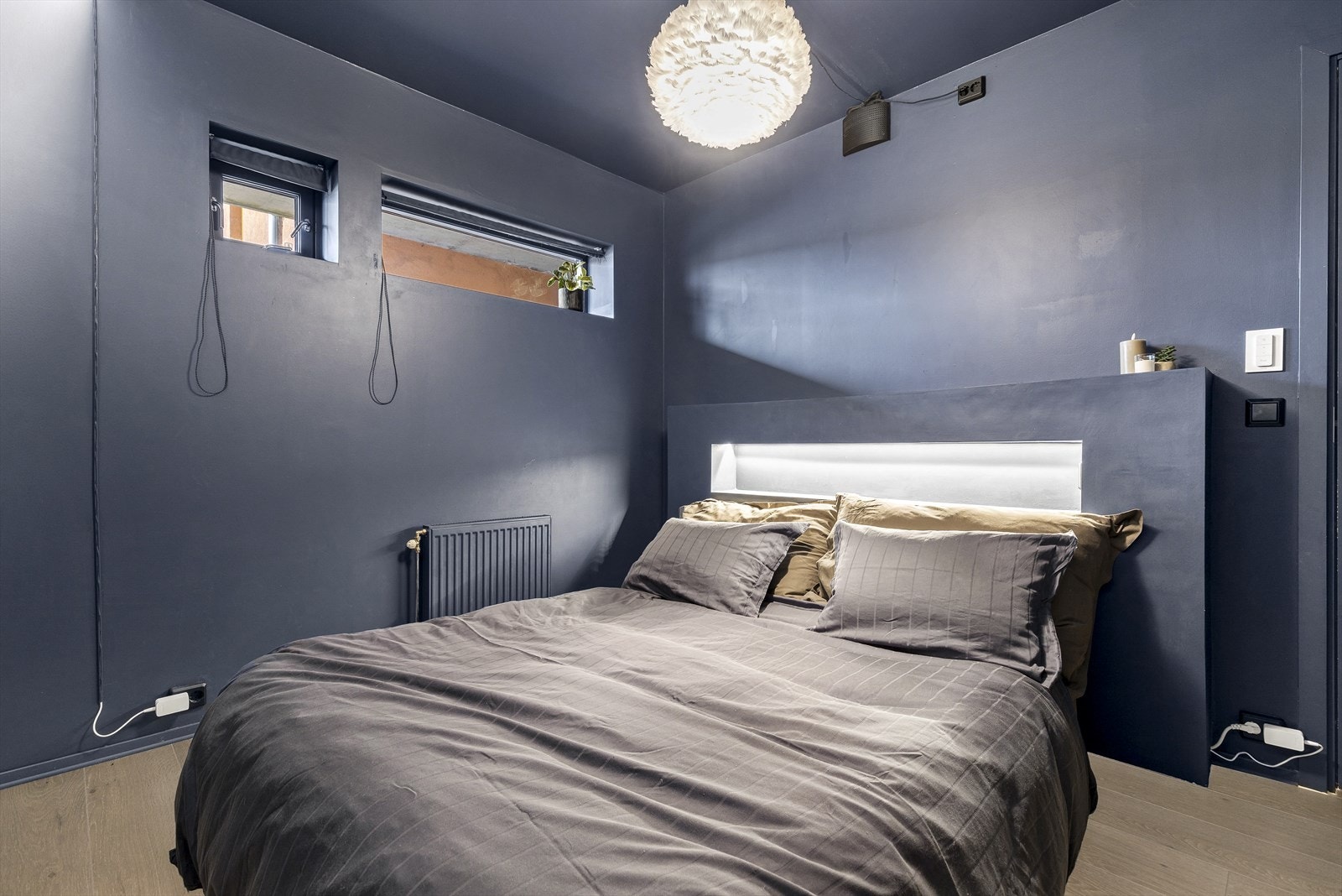 Romslig soverom med fastmontert sengegavl i samme farge som resten av rommet Galleribilde