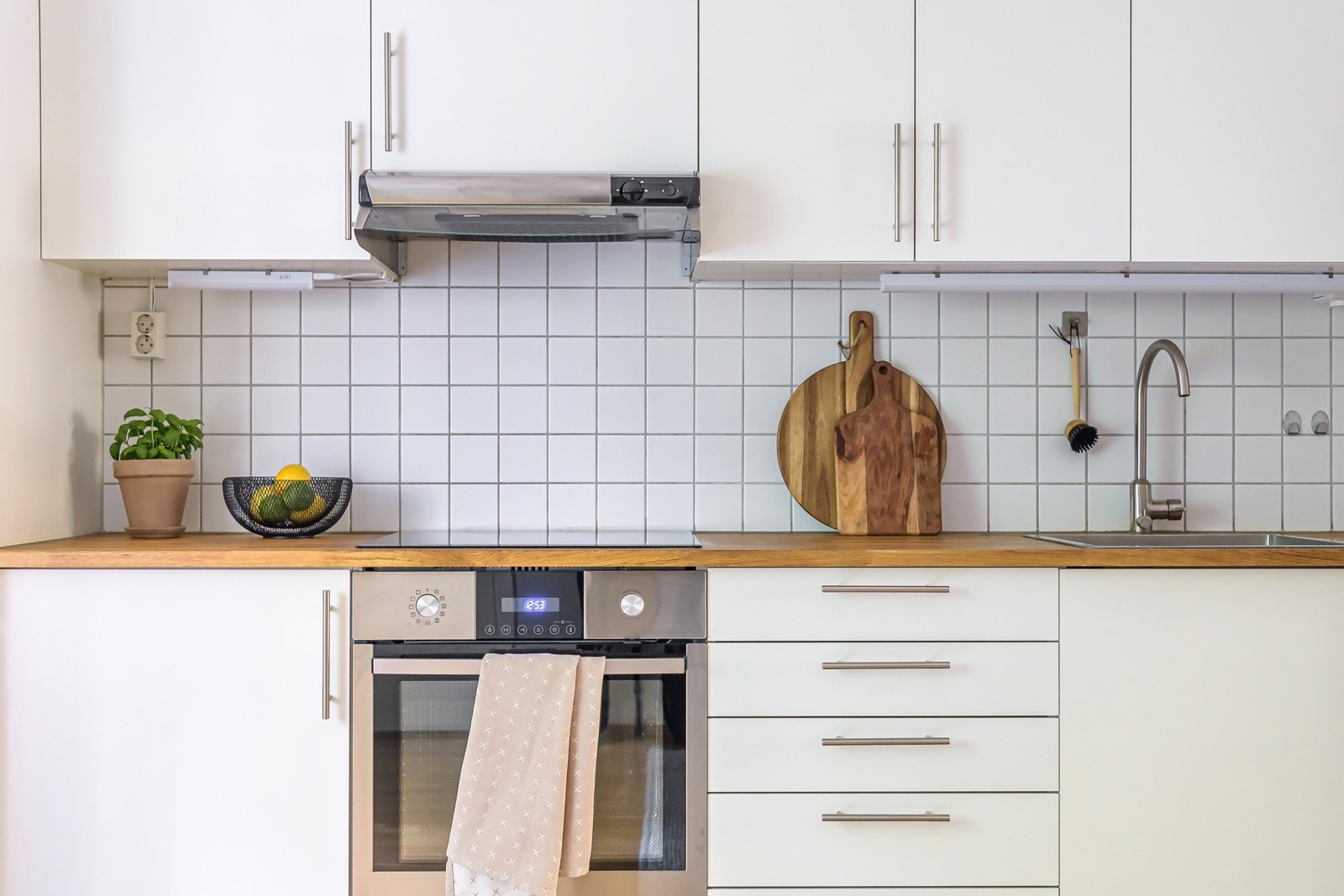 Kjøkkeninnredning med slette fronter, heltre benkeplate som ble byttet i 2022, fliser på bakvegg, oppvaskkum, ventilator og innfelte hvitevarer som stekeovn, induksjonsplatetopp samt frittstående kjøl/frys og oppvaskmaskin. Galleribilde