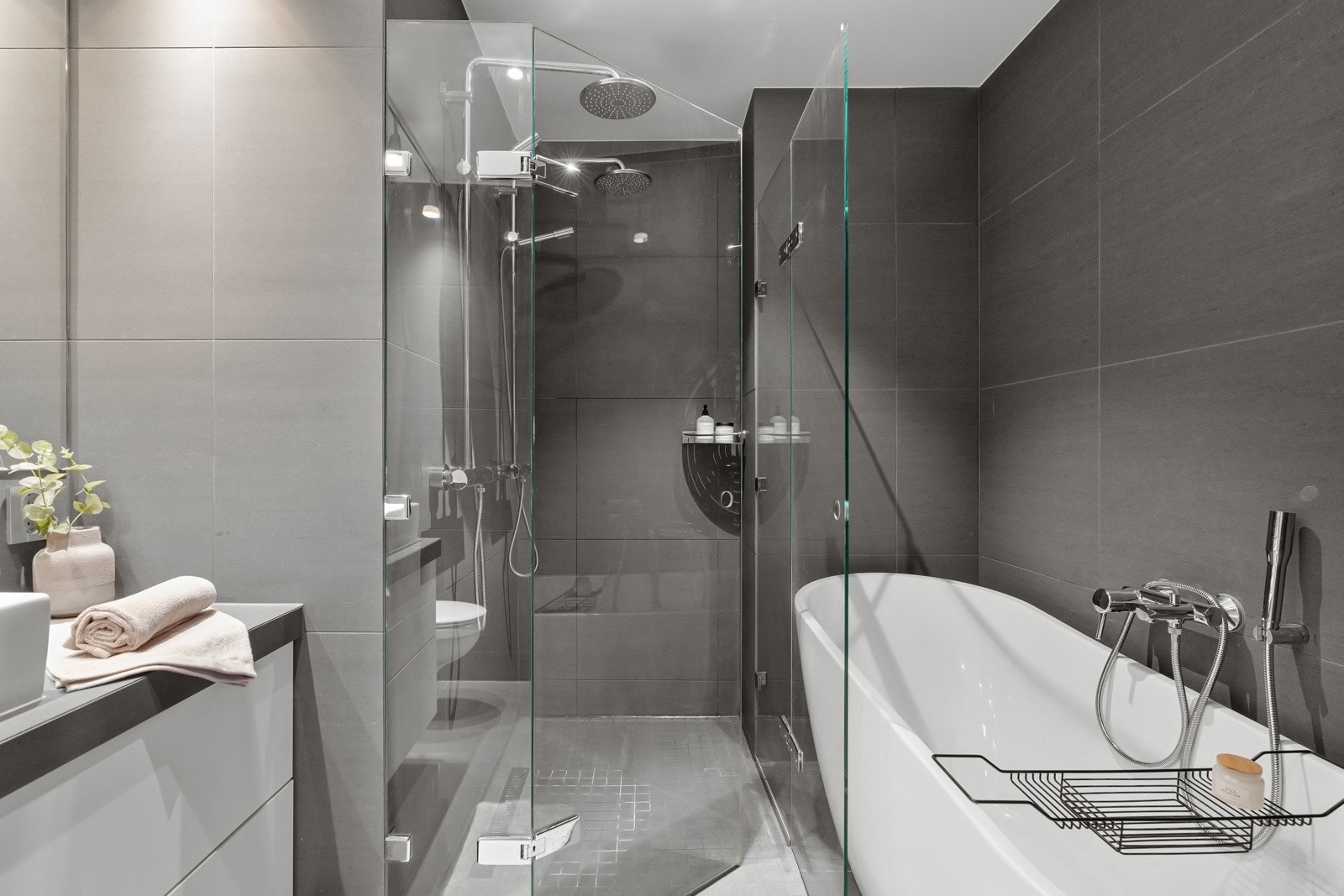 Baderomsinnredning med flislagt topp, servantskuffer og porselensservant. Galleribilde