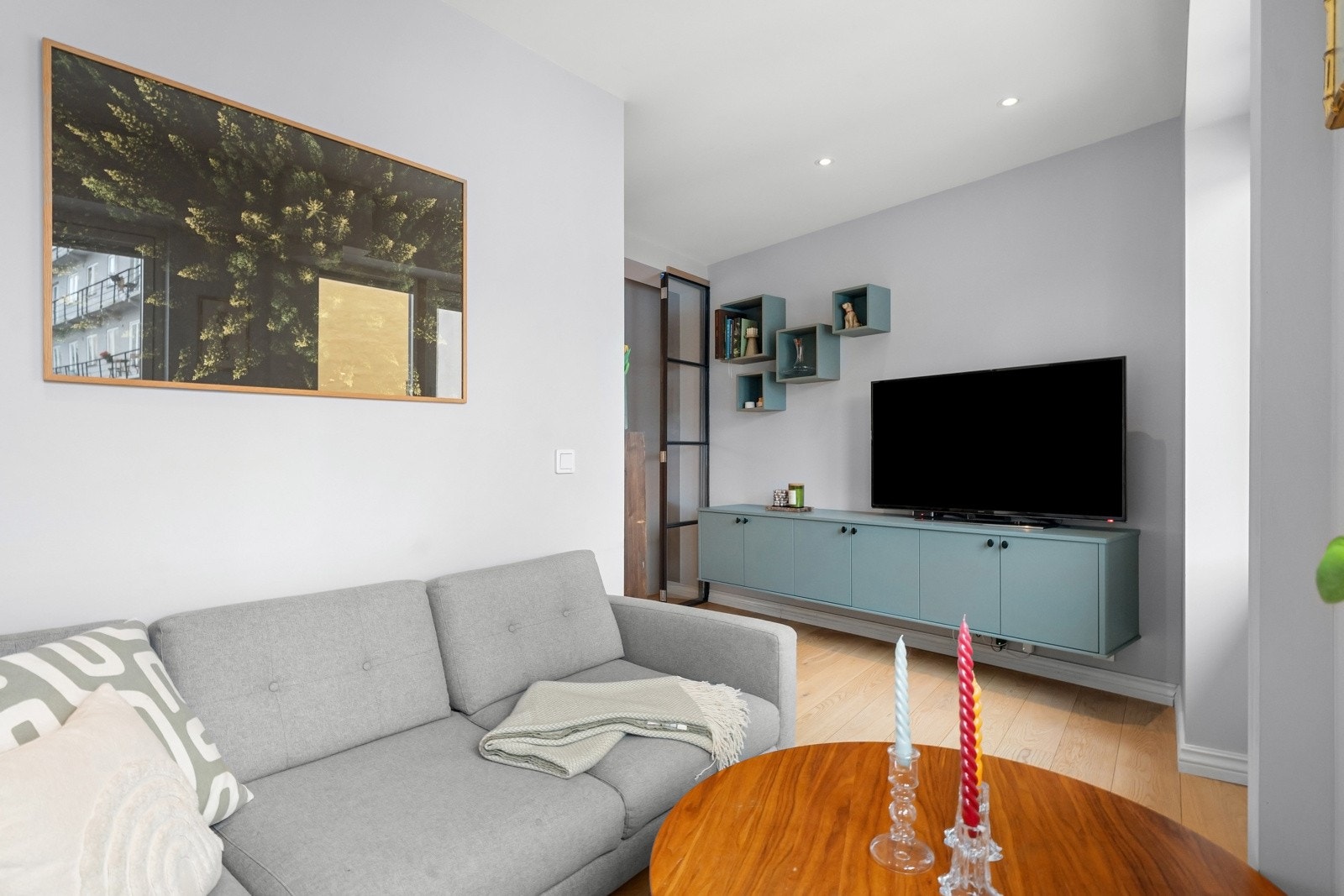 Plassbygget TV- og mediemøblement med vegghyller i stue. To tv-uttak i rommet. Galleribilde