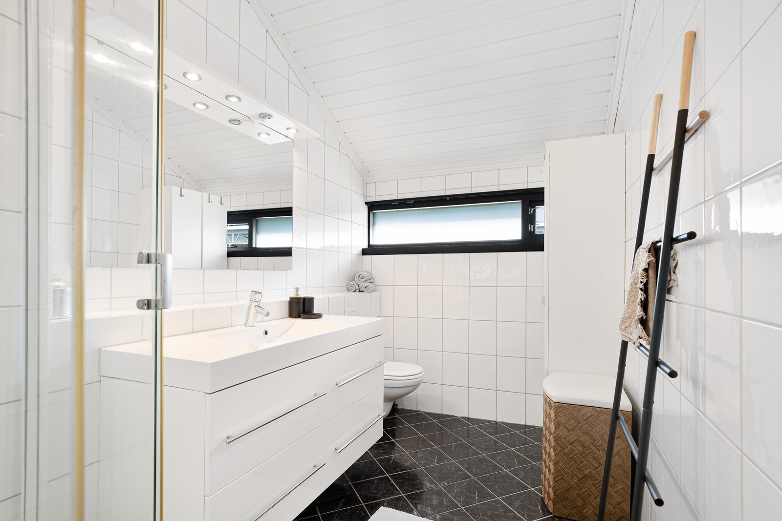 Det er satt inn ekstra skap for oppbevaring og badet har nøytrale og minimalistiske farge- og materialvalg. Galleribilde