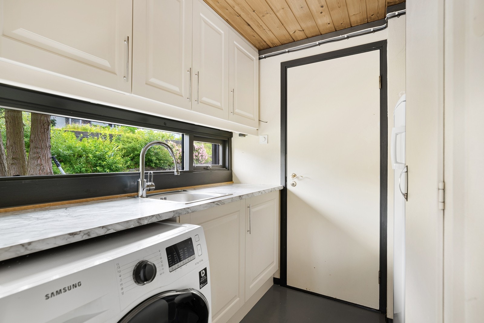 Vaskerommet har egen vask, nisje til vaskemaskin, plass til separat kjøleskap og det er videre inngang til vindfang. Galleribilde