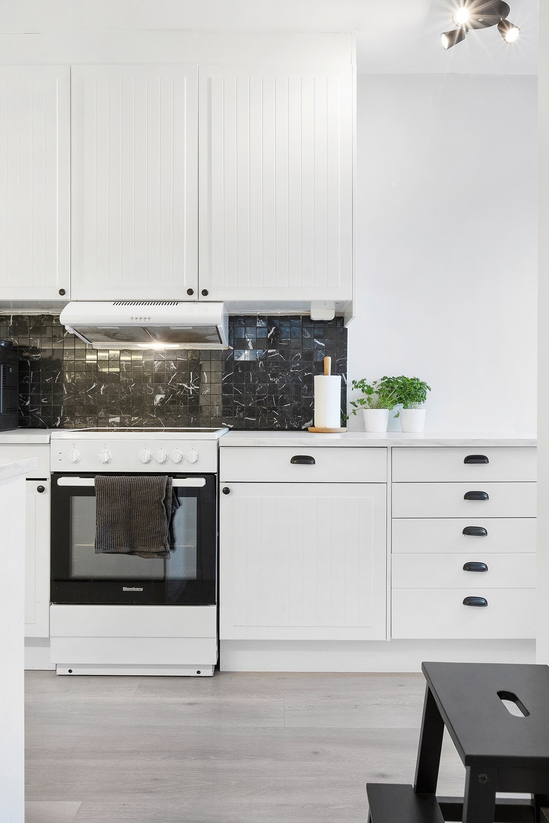 Det er godt med skapplass på kjøkkenet. Veggen over benkeplate er flissatt med laminat benkeplate. Galleribilde