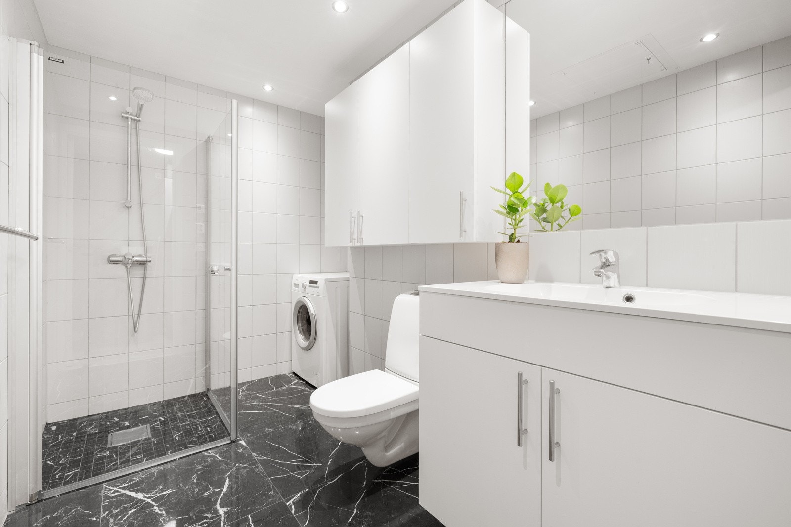 Pent flislagt baderom med varmekabler. Opplegg for vaskemaskin i egen nisje. Galleribilde