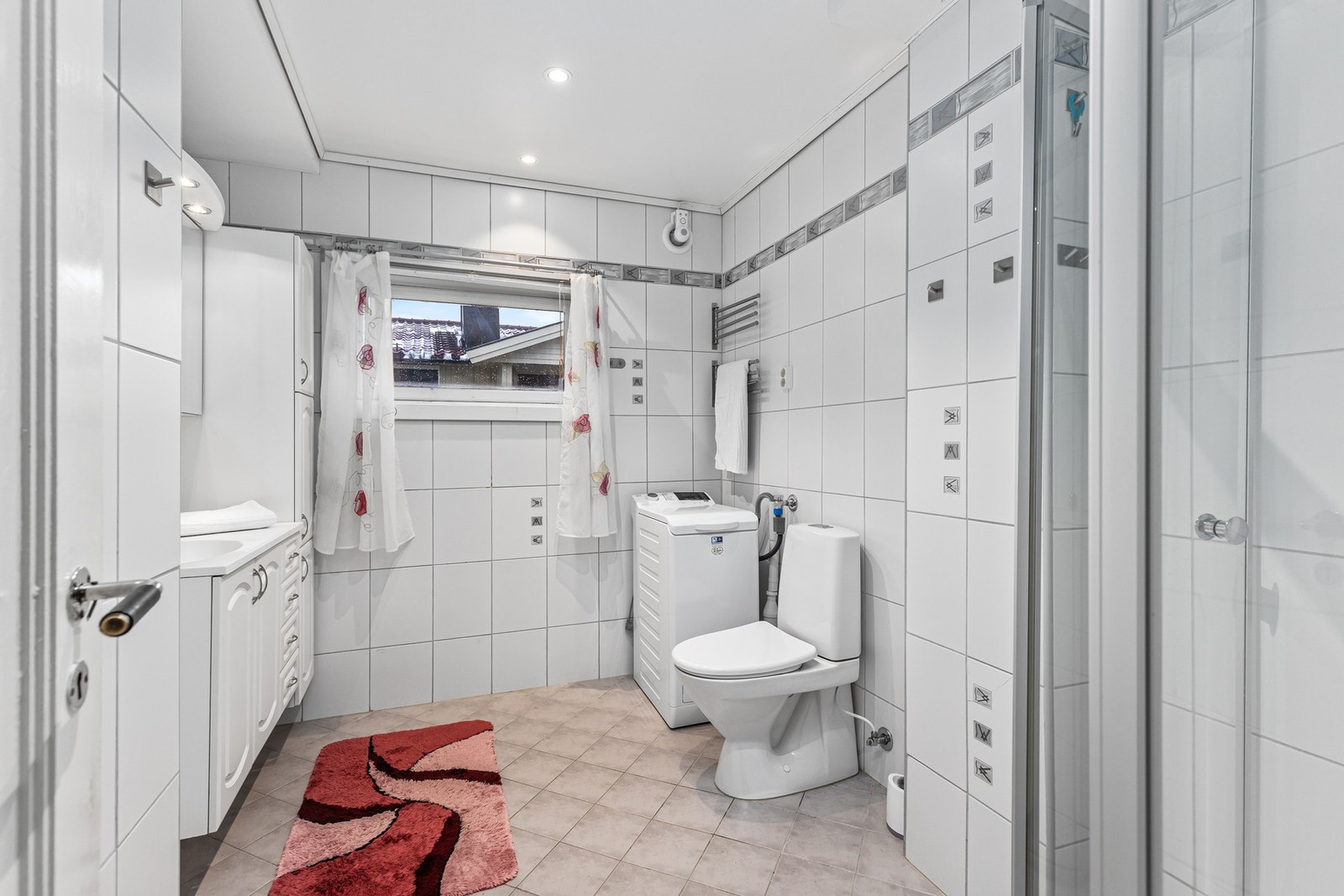 Lyst, flislagt bad med varme i gulvet og downlights i himling. Galleribilde