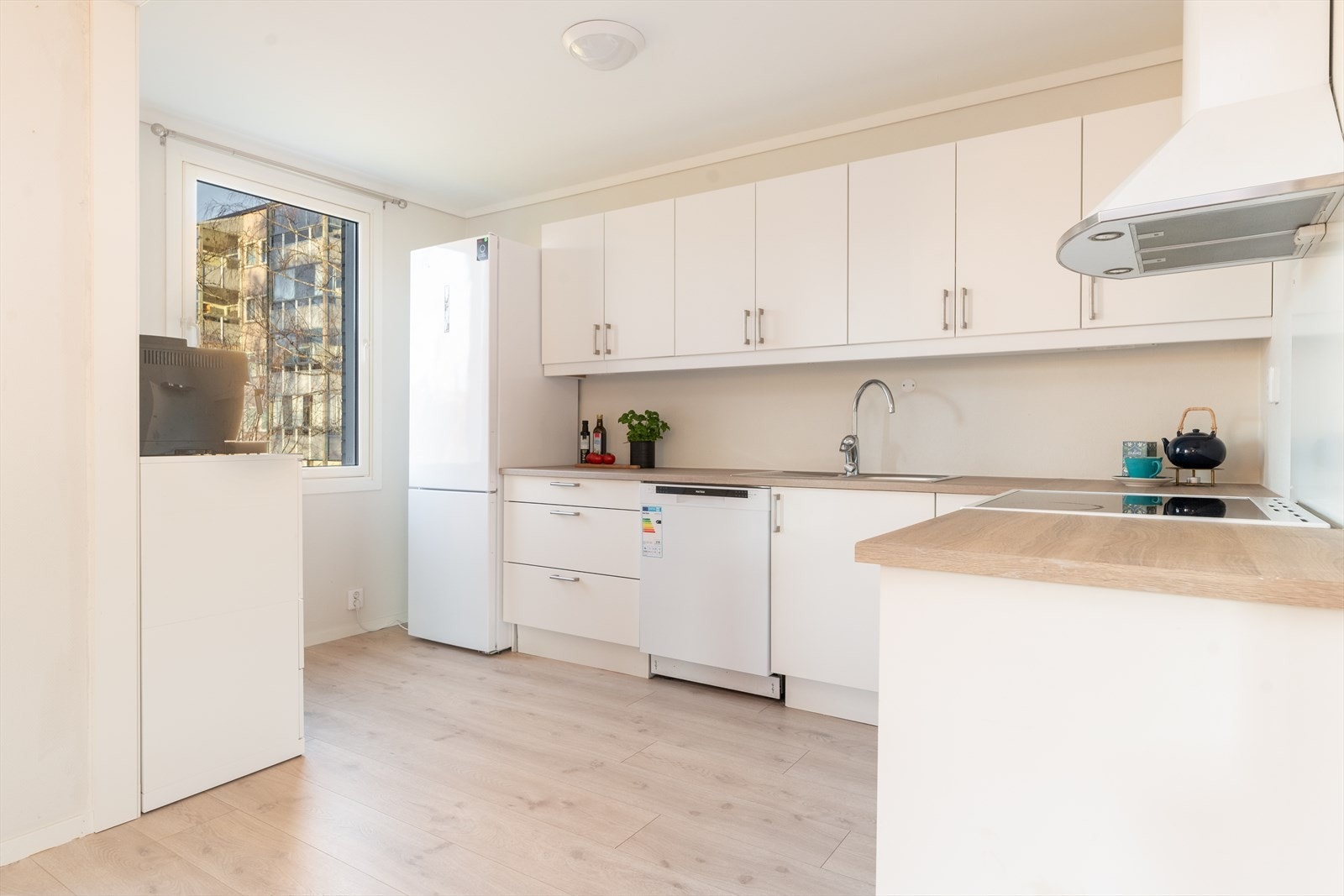 Kjøkkenet har en fin, åpen løsning mot stuen, og det er godt med oppbevaringsplass i hvit innredning fra 2014. Galleribilde