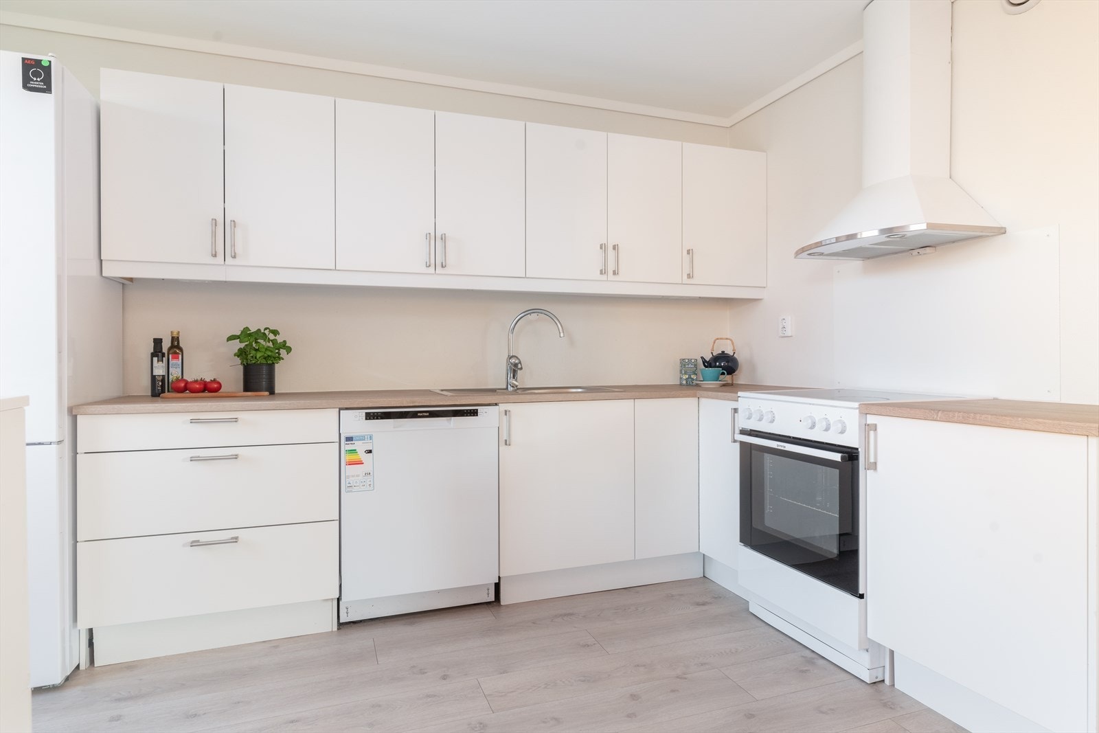 Det er også gode arbeidsflater på laminerte benkeplater, og over kokesonen er det en stilig ventilator med avtrekk via balansert ventilasjonsanlegg. Kjøkkenet har avsatt plass til frittstående hvitevarer som oppvaskmaskin, komfyr og kjøl/fryseskap. Galleribilde