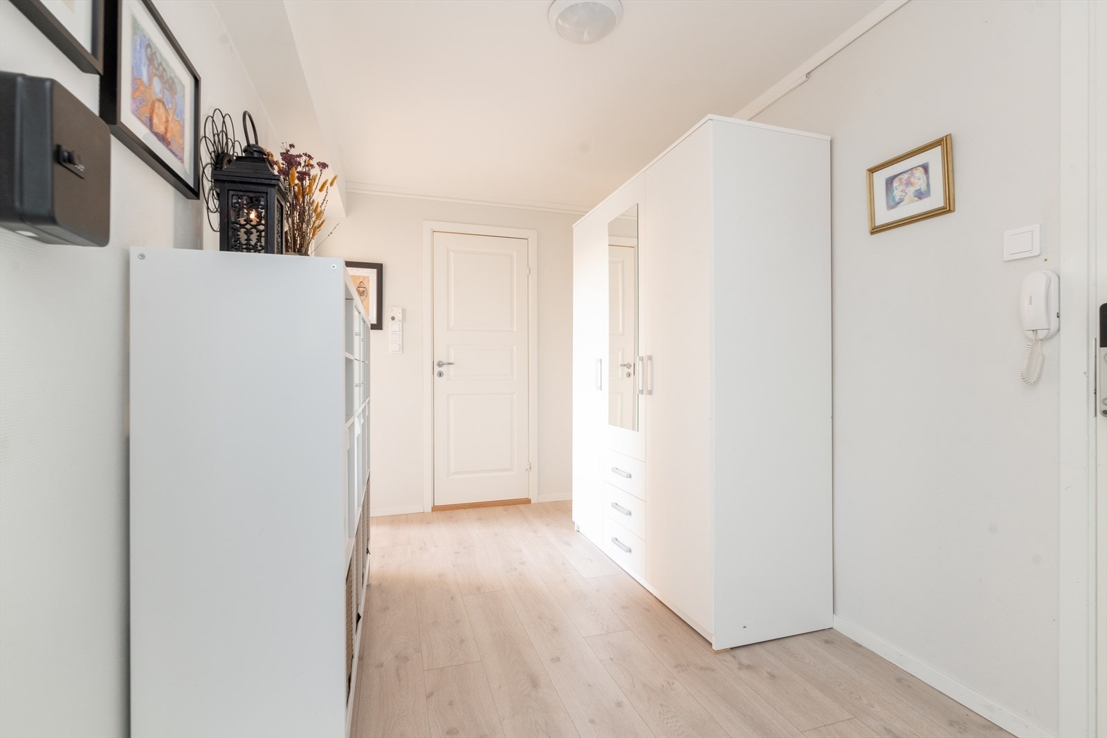 En liten trapp opp fra hovedinngangen kommer man inn i leilighetens romslige gang, hvor det er enkel adkomst via nyere inngangsdør med kodelås fra Yale. Her er det god plass til oppbevaringsmøblement. Galleribilde