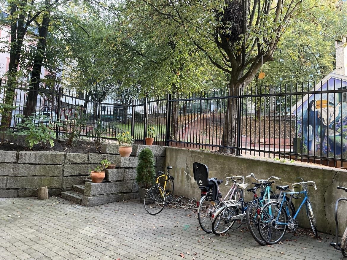 Pen, hellelagt bakgård med sykkelparkering og sittegruppe. Galleribilde