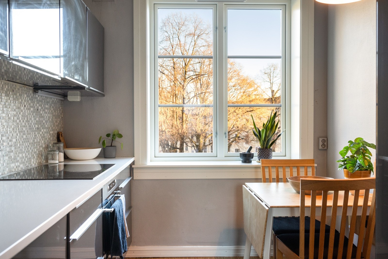 Moderne, separat kjøkken som består av fronter i grå høyglans og benkeplate i laminat. Galleribilde