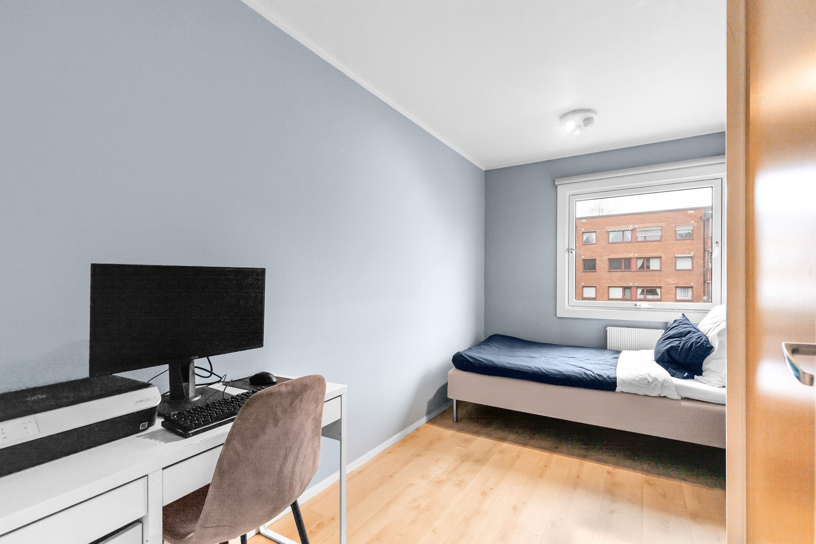 Romslig soverom malt i en elegant blå-tone med god plass til seng og bord. Galleribilde