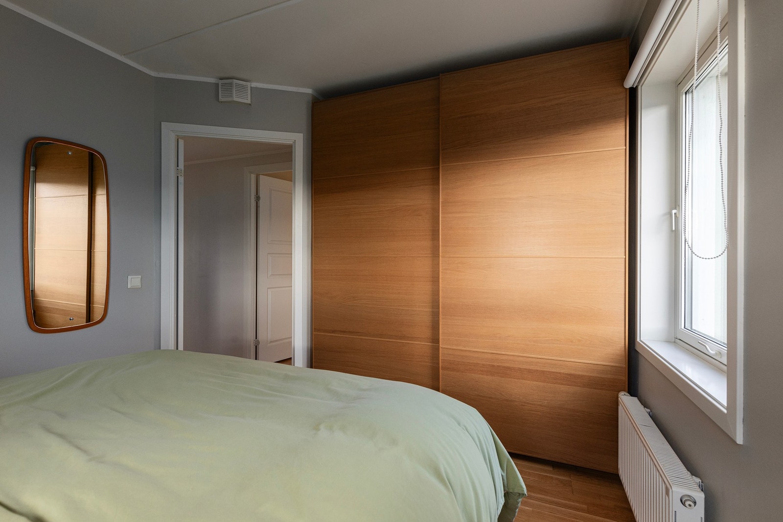 Innfelte garderobeløsninger på soverommet gir rikelig med oppbevaringsplass og bidrar til et ryddig og stilrent uttrykk. Galleribilde