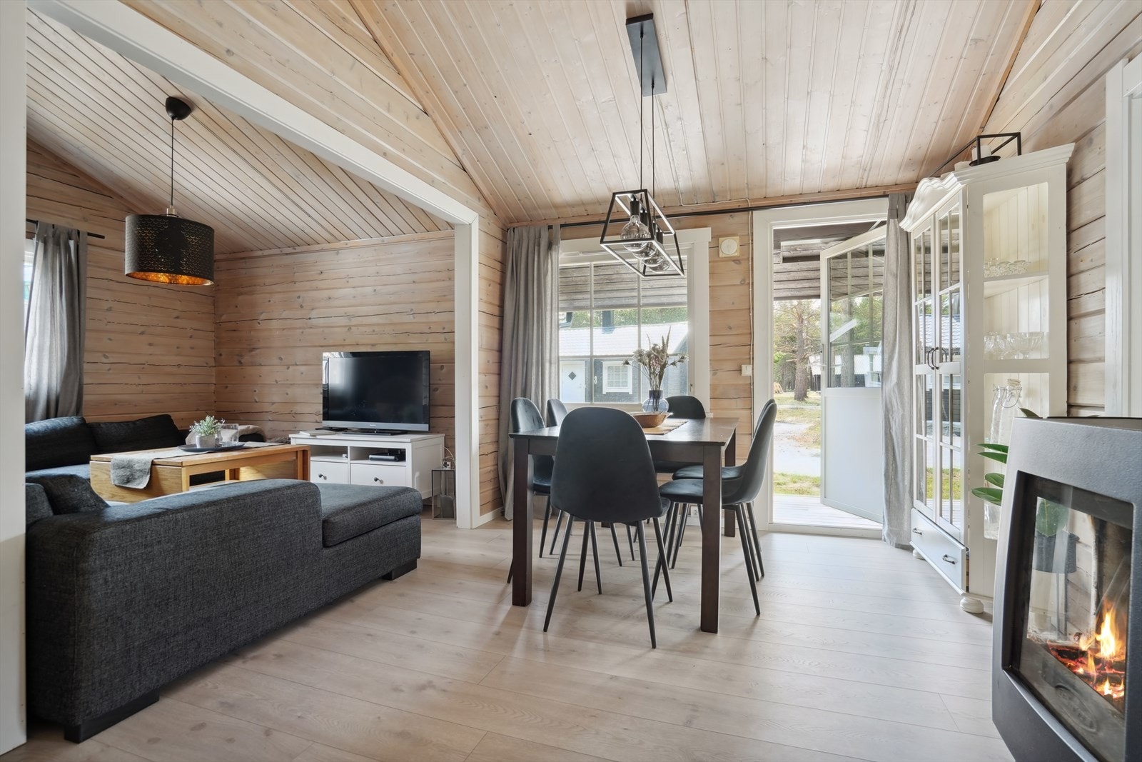 Del av stue - legg merke til at det er installert vedovn og at man har utgang til terrasse fra stuen Galleribilde
