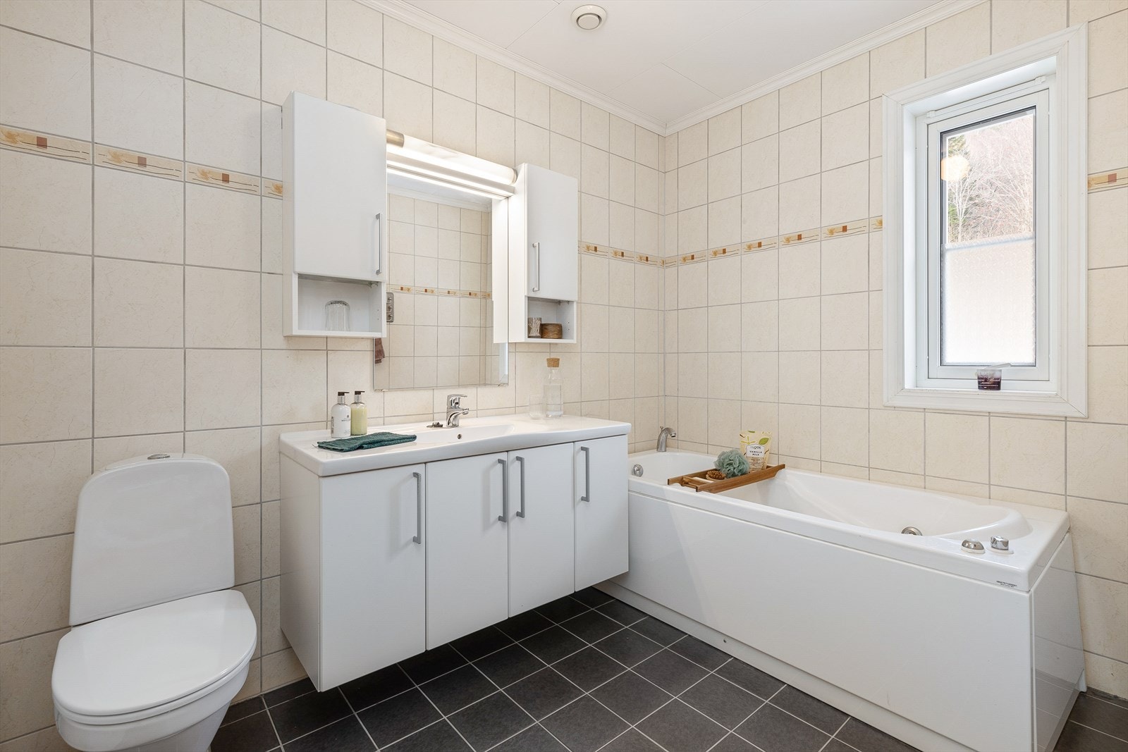 Bad med microsement frå 2023 på golv og veggar. Badet er utstyrt med toalett, dusjhjørne og servant med innredning. Galleribilde