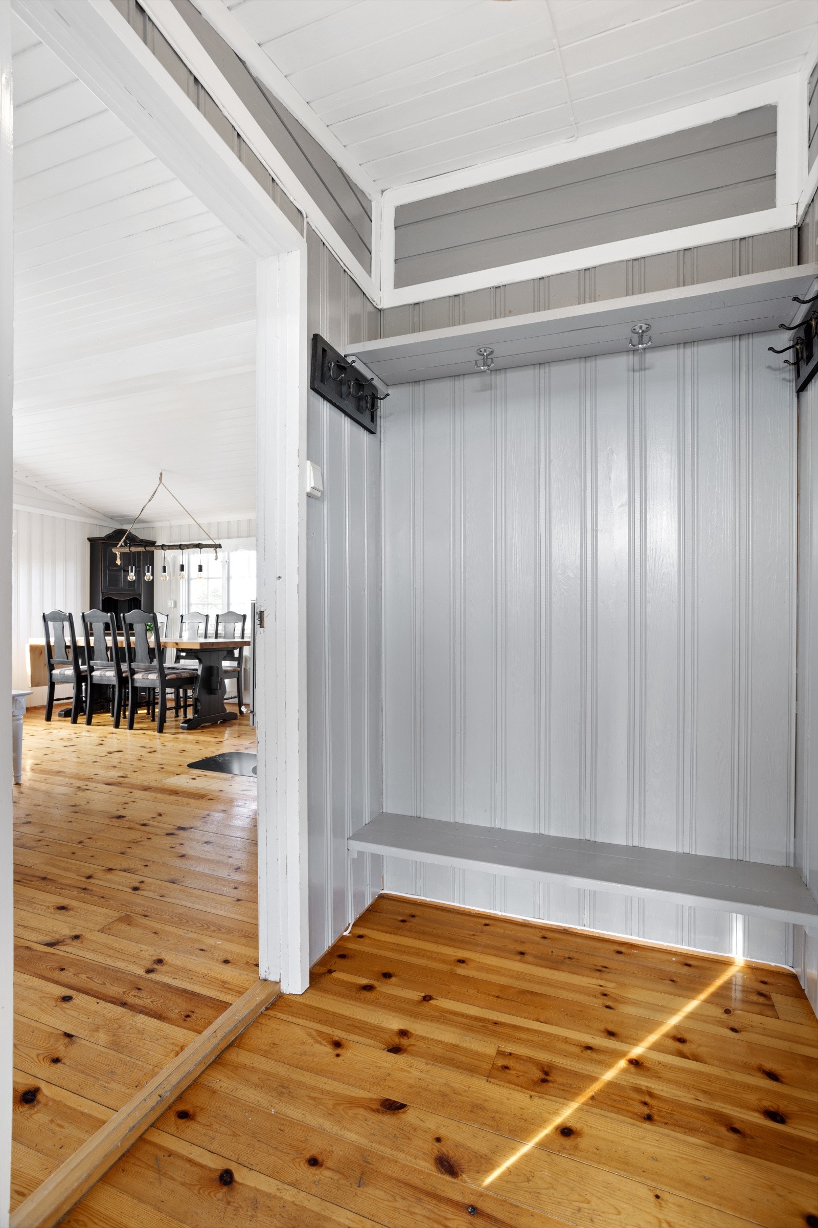 Lyst vindfang med lysmalte overflater. I gangen er det plass til å henge fra seg yttertøy og sette fra seg sko. Galleribilde