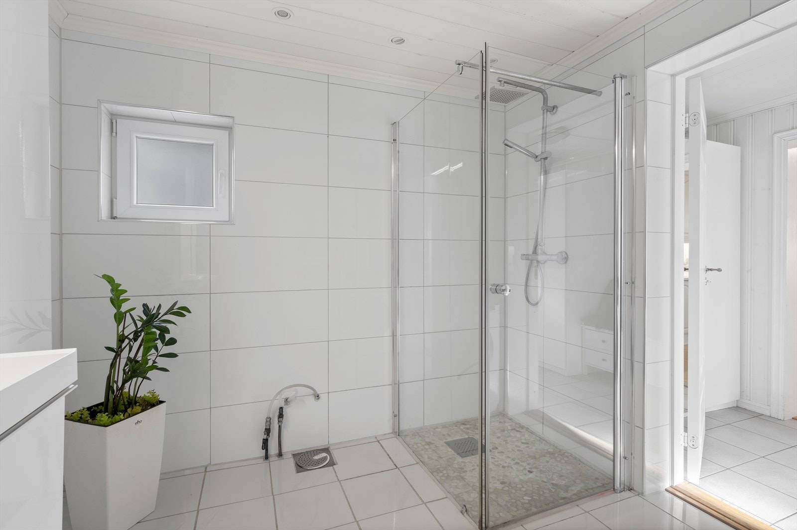 Badet er flislagt med varmekabler. Innredet med dusjnisje, vegghengt toalett, opplegg for vaskemaskin Galleribilde