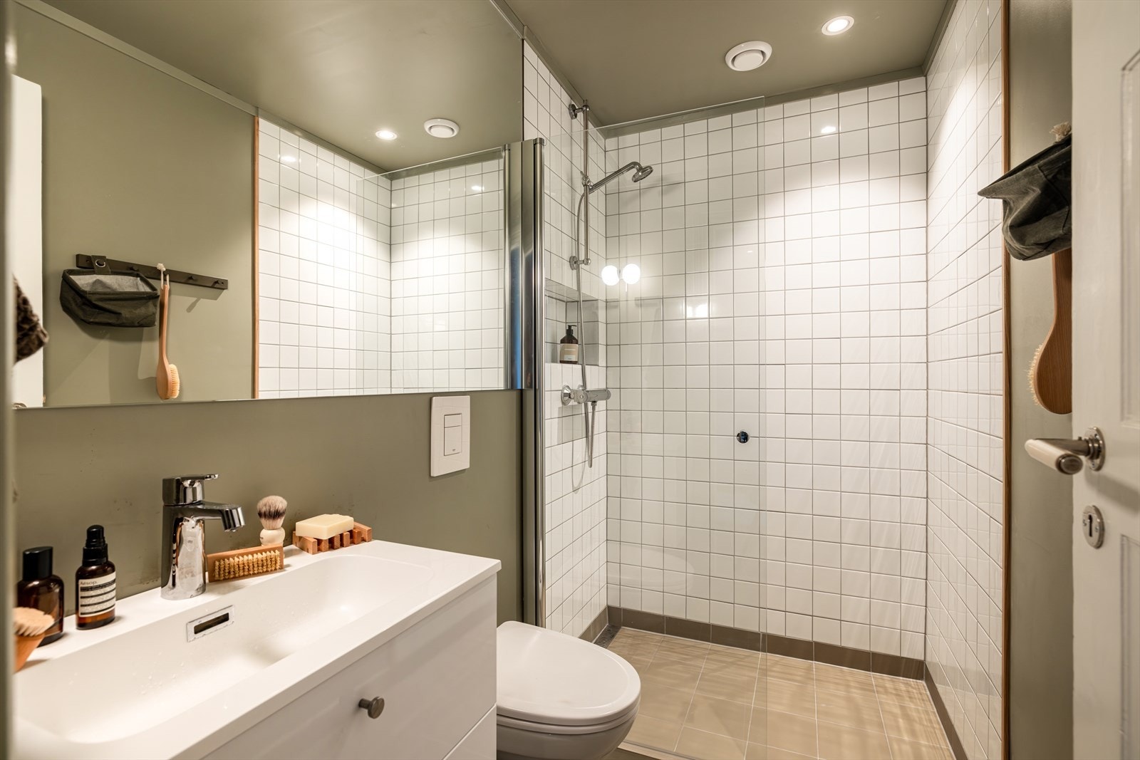 Lekkert bad nyoppusset i 2024 med varmekabler i gulv og downlights i himling. Servantskap med heldekkende vask, vegghengt toalett, speil over servant og dusjhjørne. Galleribilde