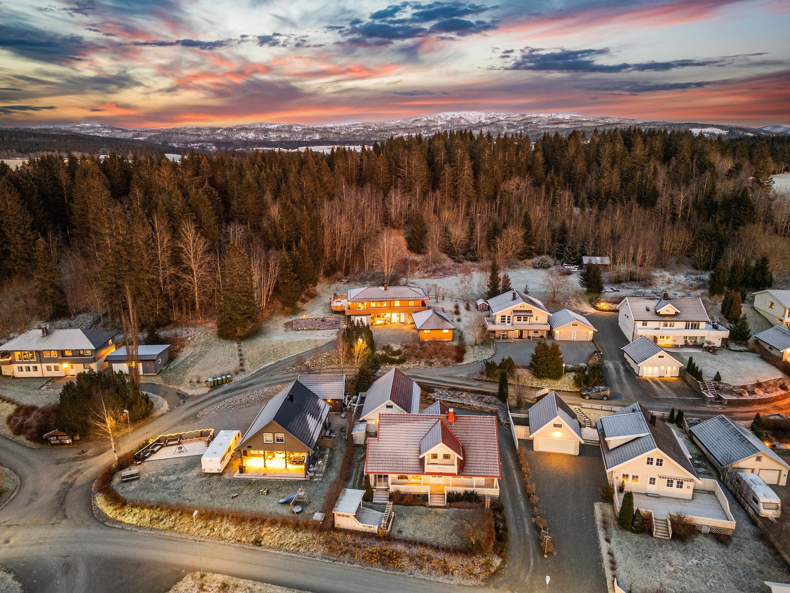 Oversikt over området. Boligen ligger pent plassert mot skogen og lekeplassen. Galleribilde