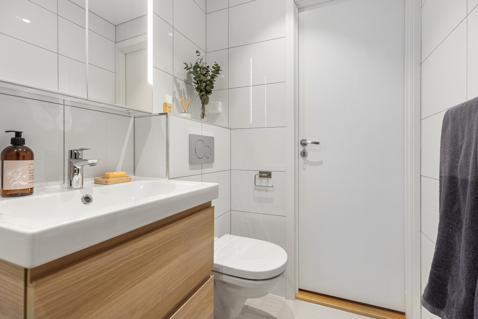 Bad/wc består av vegghengt wc, servant m/underskap, speil m/lys, veggskap, inn-/utadslående dusjdører og opplegg for vaskemaskin. Veggskap må fjernes for å få plass til vaskemaskin. Galleribilde