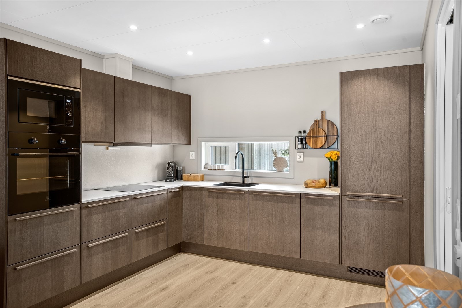 Kjøkkenet er nøyaktig tegnet der både både benkeplaten og kitchenboarden er lik. Det er noe downlights i himling. Galleribilde