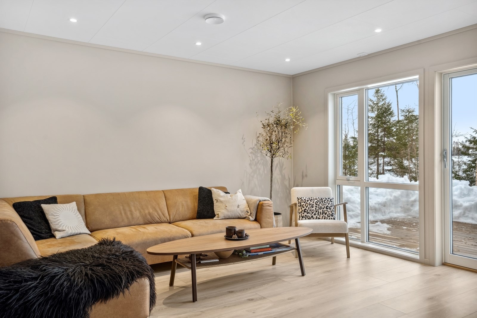 Eiendommen ligger skjermet til på en høyde og her får du bla. en nydelig utsikt over jorde - uten spesiell innsyn. Her i stuen er det vinduer enda ned til gulv som gir et fint lysinnslipp. Galleribilde