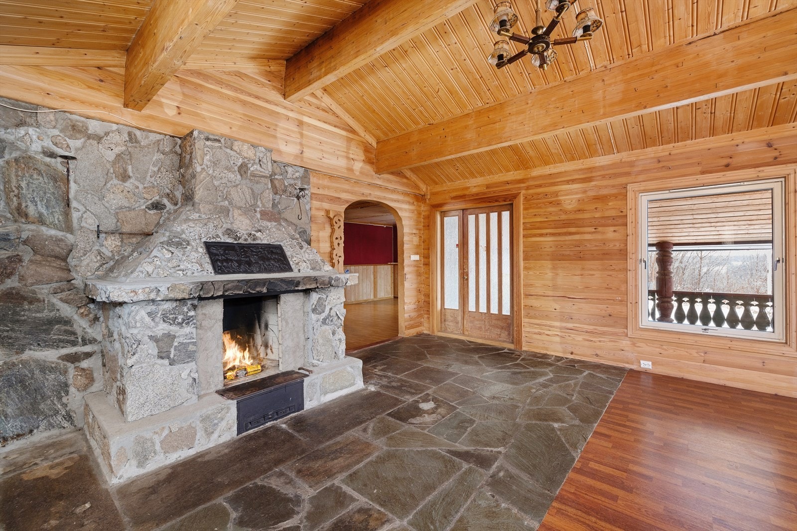 En rustikk peis i naturstein preger rommet. Galleribilde